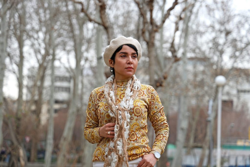 kyrgyzstan woman wearing a beret and patterned sweater outdoors