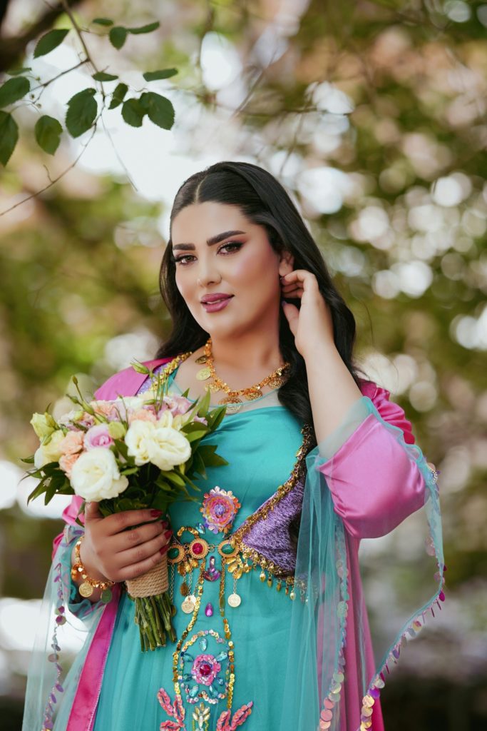 uzbekistan woman in a blue dress holding a bouquet of flowers