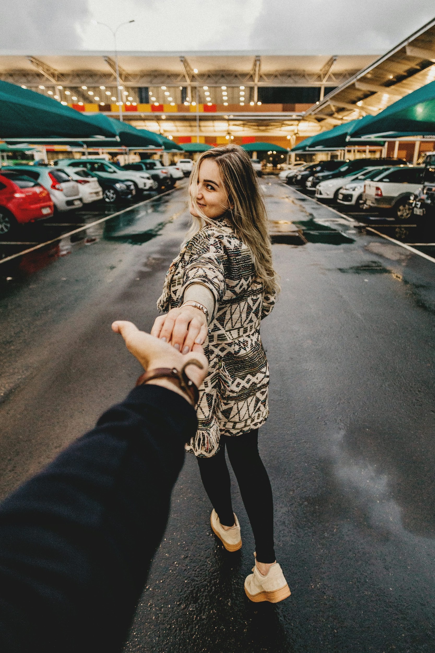 man and woman walking near parking lot take me there photography