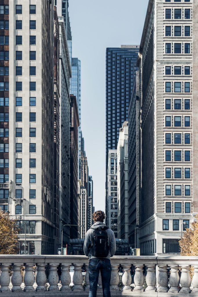 man standing beside rail during daytime