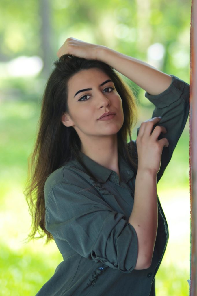 woman in gray shirt holding her hair
