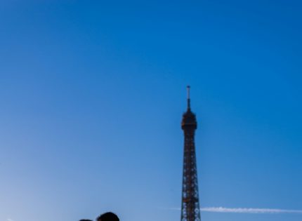 a couple kissing in front of the eiffel tower